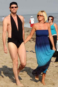 A swim-suited Jim Carrey strolls on the beach with girlfriend, Jenny McCarthy